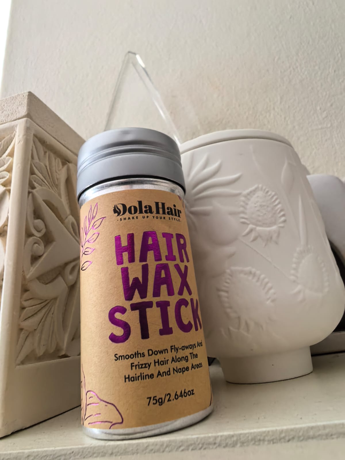 Close-up of DolaHair hair wax stick for flyaways and edge control