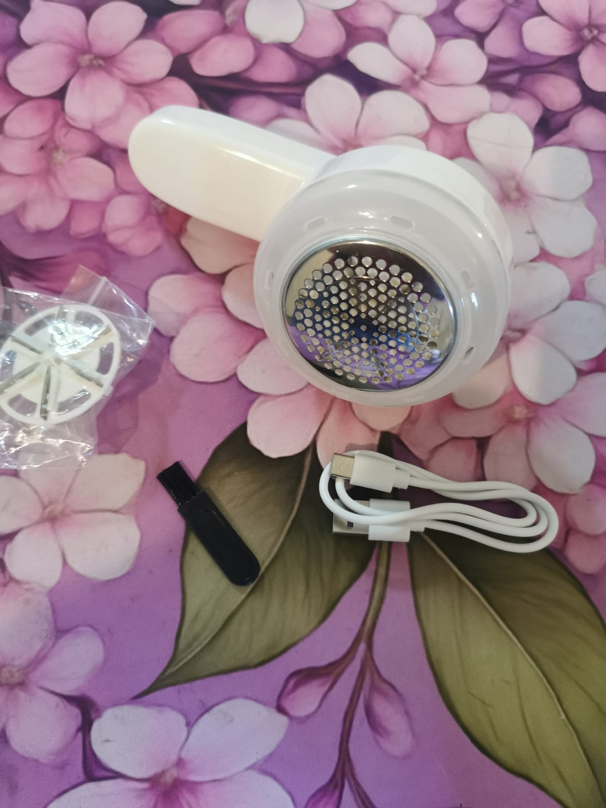 Close-up of the protective metal shaving head on the lint remover