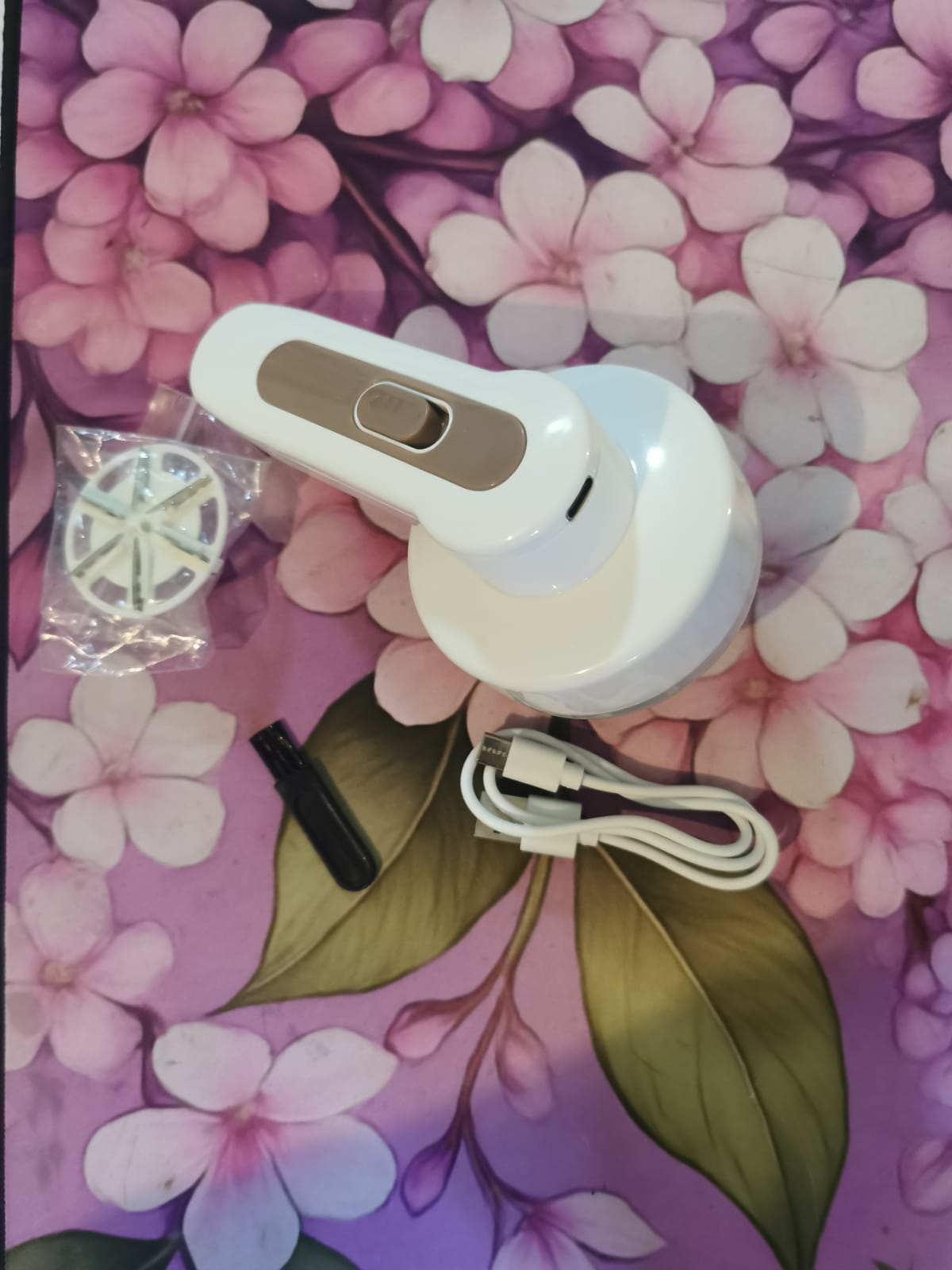 White rechargeable fabric shaver with charging cable and cleaning brush