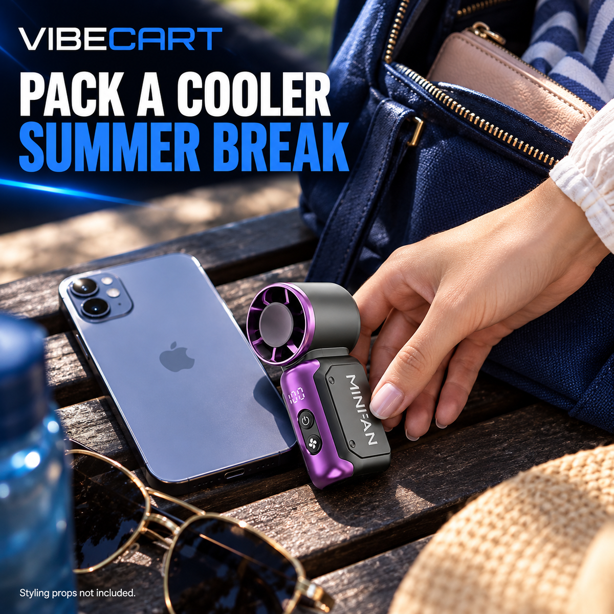 Mini fan beside a phone and handbag for everyday size context