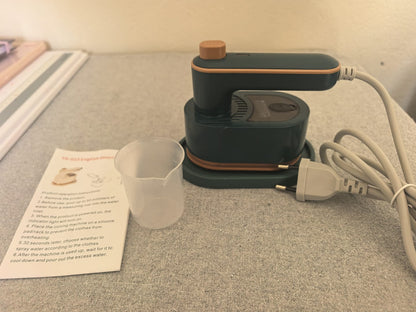 Green foldable travel mini iron with stand, measuring cup and power cord